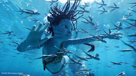 Still from Avatar The Way of Water showing a young blue Na'vi swimming underwater
