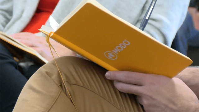 Designer writing in Modo notebook